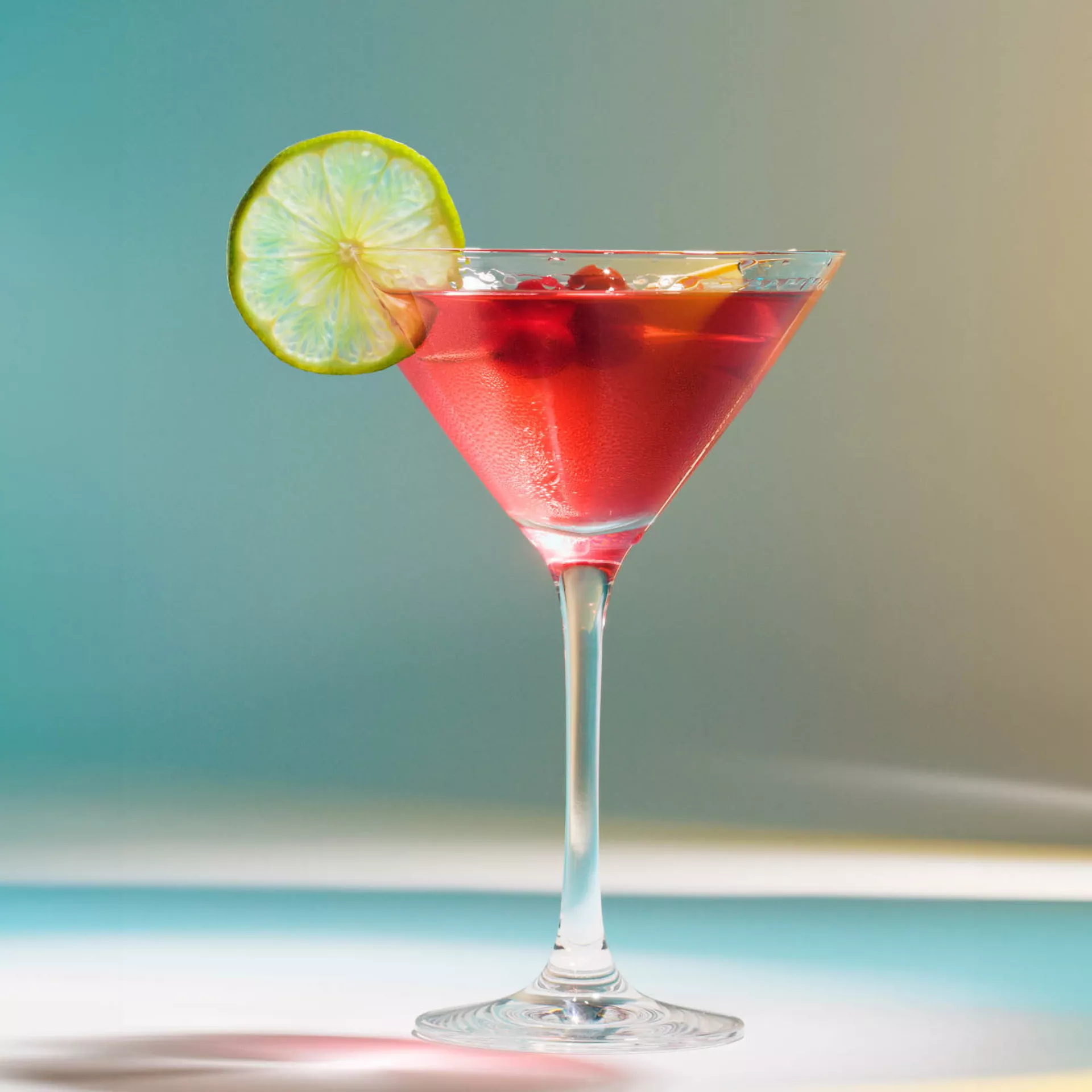 Ein roter Cocktail mit einer Limettenscheibe am Rand