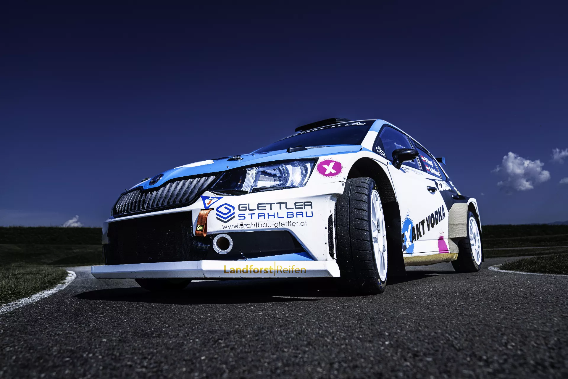 Ein weiß-blaues Auto fährt eine Straße entlang