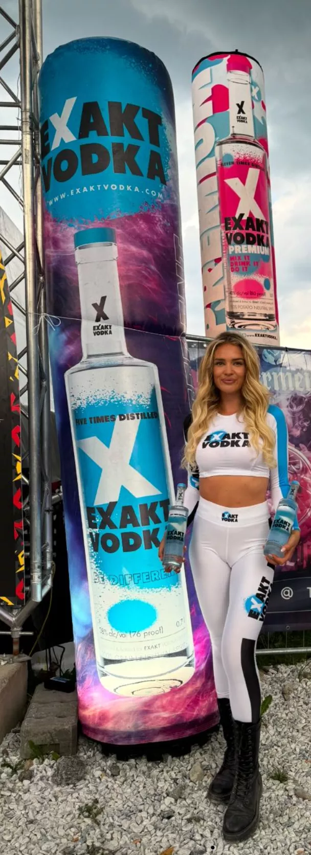 Eine Frau steht neben einer großen Flasche Wodka