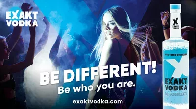 Eine Frau die sich gerade zur Kamera umdreht, neben ihr eine Flasche Vodka.