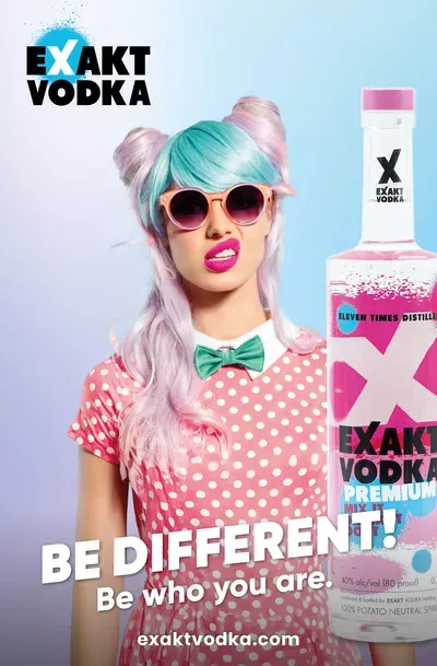 Eine Frau mit blau-rosa Haaren in einem rosa Kleid, neben ihr eine Flasche Vodka.