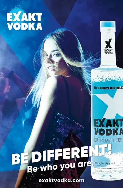 Eine Frau steht neben einer Flasche Wodka.