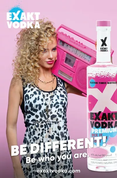 Eine Frau hält eine pinkfarbene Boombox neben einer Wodkaflasche.